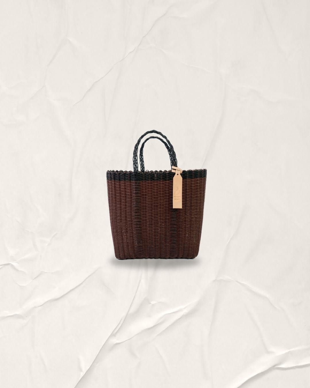 Brown woven handbag with black accents on a white background