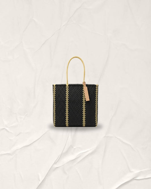 Hand-woven Pilar Bag in Anchor Black with two vertical Serene Cream lines. This medium-sized sustainable tote features cream handles and is crafted from recycled plastic in Indonesia. A washable and foldable bag with a minimalist architectural design